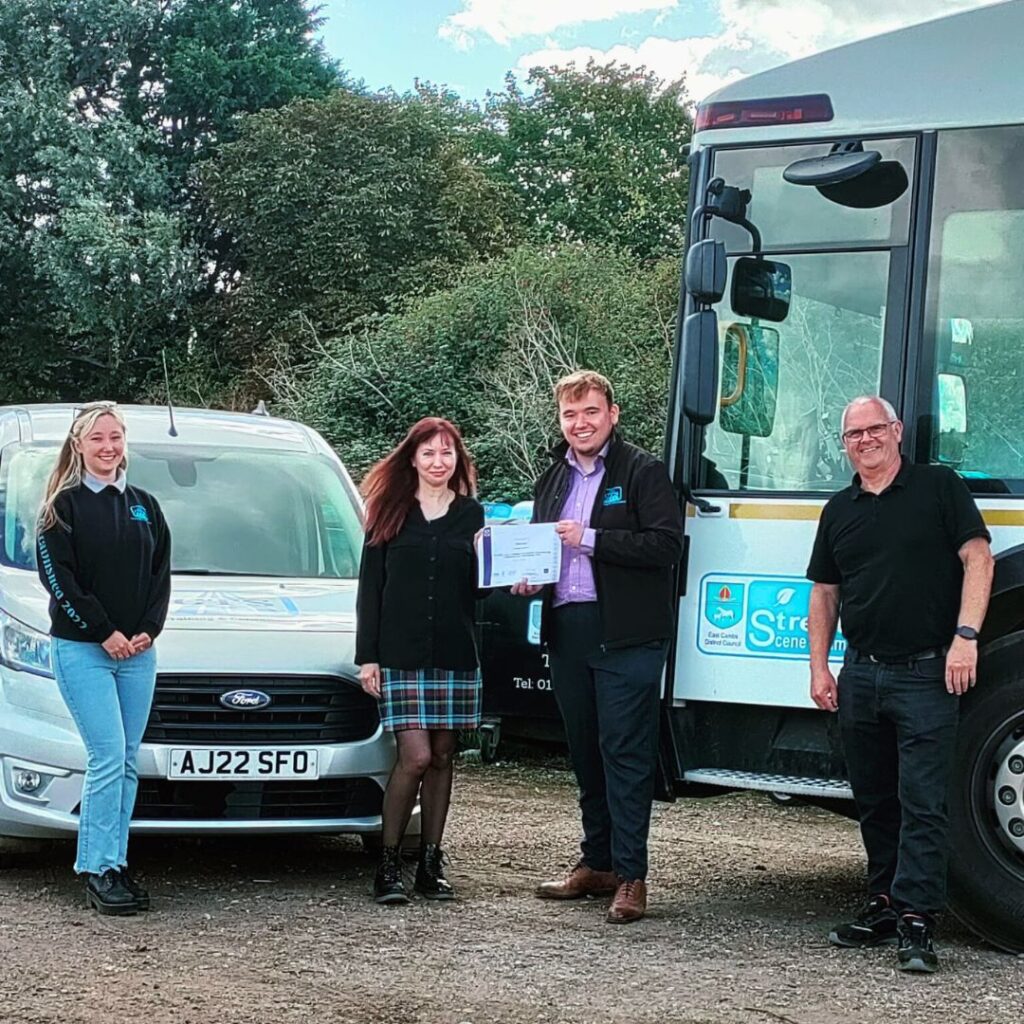 CTS presenting Claire from East Cambs District Council with her Transport Manager CPC certificate in front of the CTS van and an East Cambs Street Scene lorry