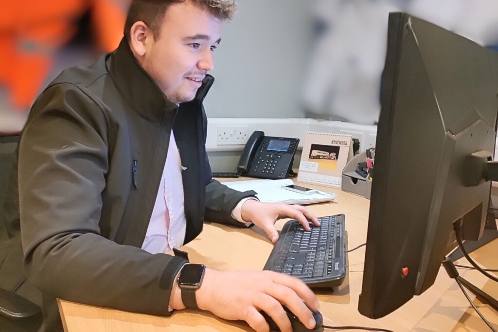 Tom at the computer carrying out compliance work
