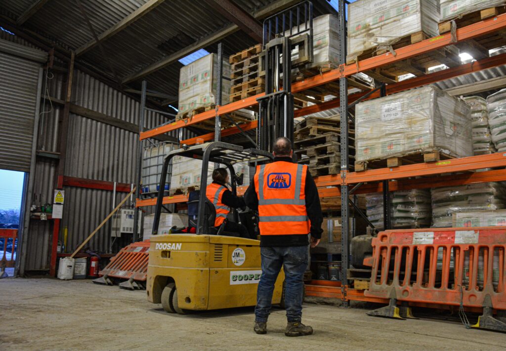 Instructor watching a candidate stack a pallet at height